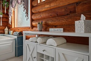 A bathroom with a wooden wall, a white sink, a towel rack, and a sign that says 'Relax Unwind Enjoy'. - Cliffrose Cabin | Panoramic Views, Near Zion, BBQ, 2min to Downtown! (Kanab)