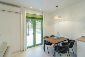 A dining area with a table, chairs, and a hanging light fixture. - Beautiful House in Álora with Pool and Views (Álora)