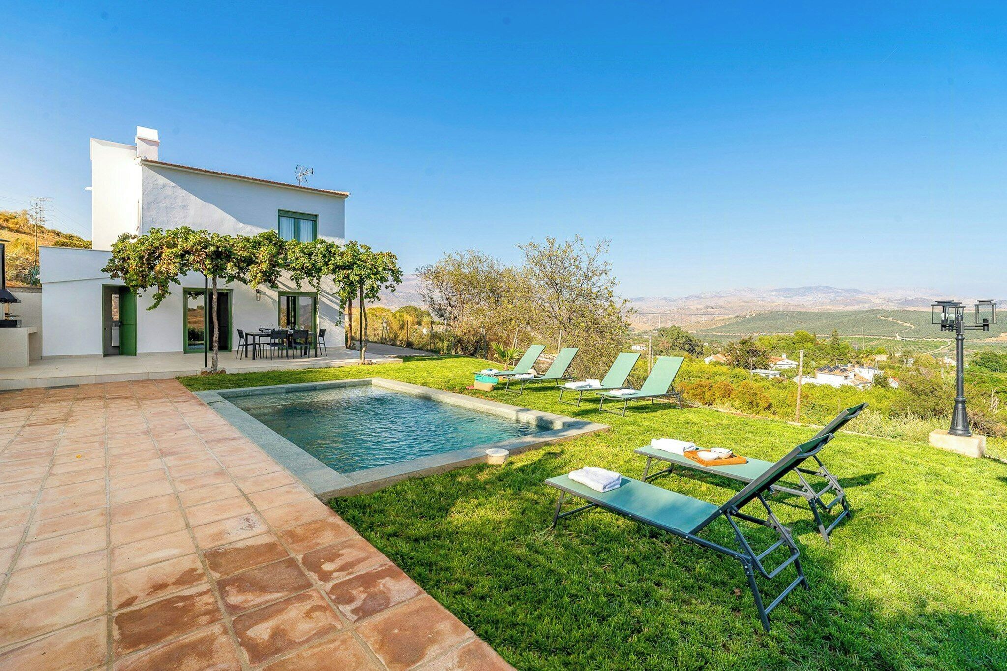 Uma casa moderna com piscina, área de estar externa e vista para a paisagem.