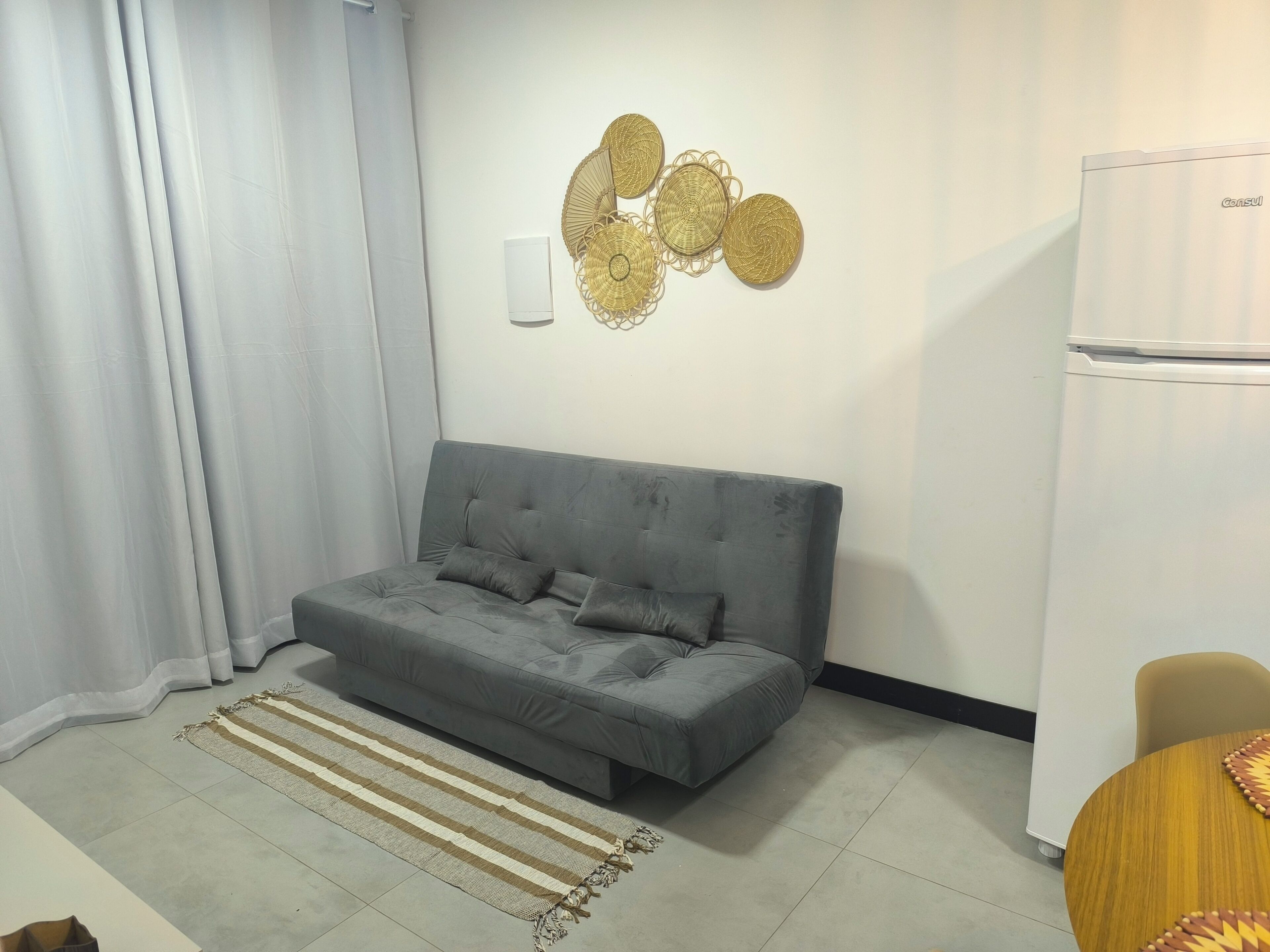 Ein modernes Wohnzimmer mit einem grauen Sofa, einem Streifen Teppich und einem Wandbild.