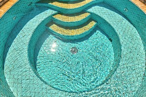 Una piscina circular con superficie texturizada y desagüe central.