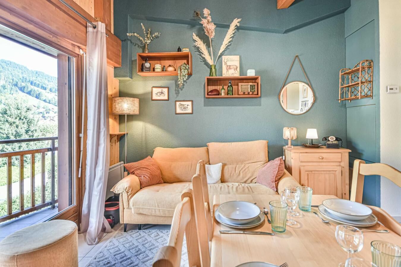 Una habitación acogedora con sofá, mesa de comedor y vistas al exterior a través de un amplio ventanal.
