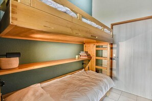 A bunk bed room with a green wall, wooden shelves, and a door. - 300m from ski slopes, 2nd floor, balcony, parking, tv, ski locker, 35m², Les Gets (Les Gets)