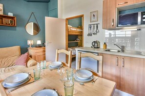 A compact kitchen with a dining area, wooden cabinets, a microwave, and a sink. - 300m from ski slopes, 2nd floor, balcony, parking, tv, ski locker, 35m², Les Gets (Les Gets)