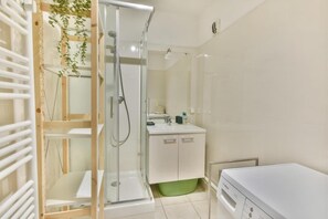 A modern bathroom with a glass-enclosed shower, a Bosch washing machine, and a white sink. - 300m from ski slopes, 2nd floor, balcony, parking, tv, ski locker, 35m², Les Gets (Les Gets)
