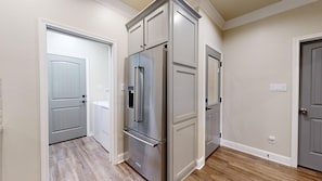 A kitchen with a stainless steel refrigerator, a built-in oven, and a dishwasher.