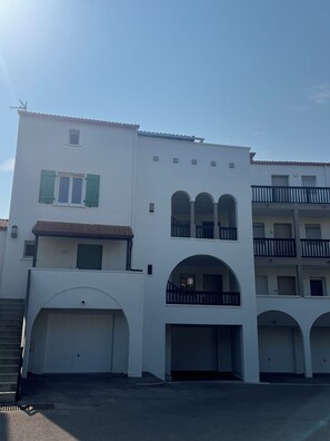 A building with a white facade, multiple balconies, and a series of arches. - Stunning apartment with a view of the lagoon, 250 meters from the beach (Saint-Cyprien)