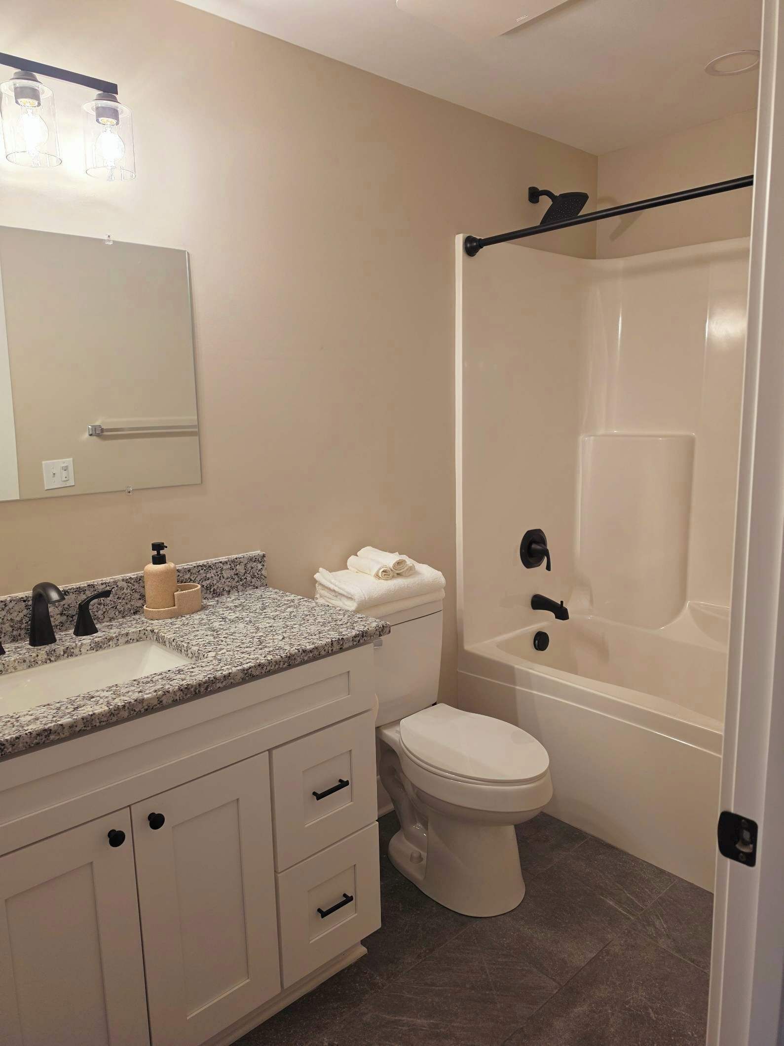 A bathroom with a toilet, sink, and bathtub.