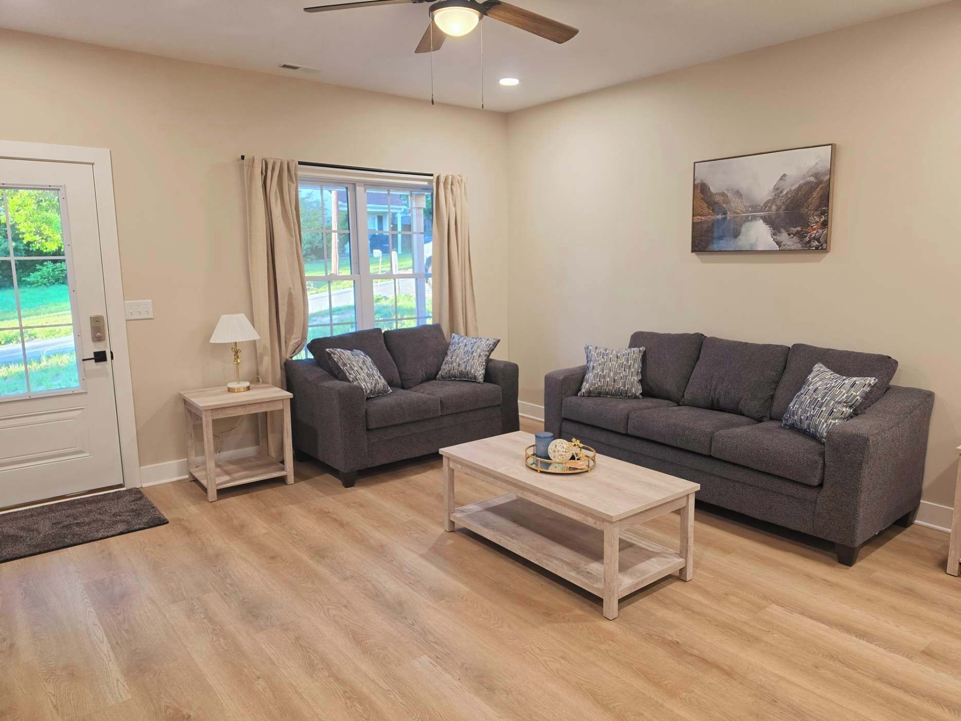 A living room with two sofas, a coffee table, a lamp, and a painting on the wall.