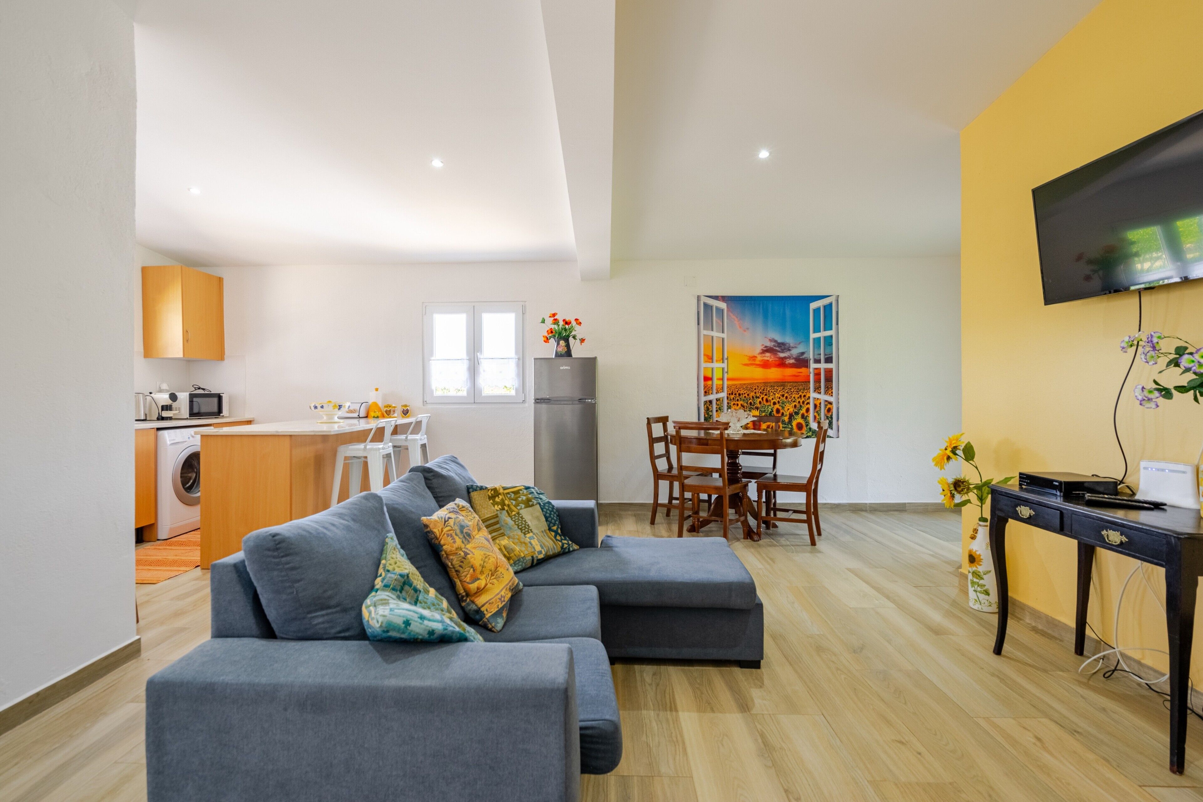 A modern apartment with a living room, dining area, and kitchenette.