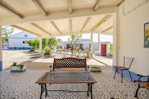 Un espace extérieur aménagé avec un banc, une table et des chaises.