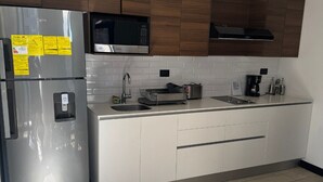 Una cocina moderna con electrodomésticos de acero inoxidable, microondas y cafetera.