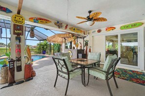 Ein Außenbereich mit Sitzgelegenheiten, Pool, Tiki-Bar und verschiedenen Dekorationselementen.