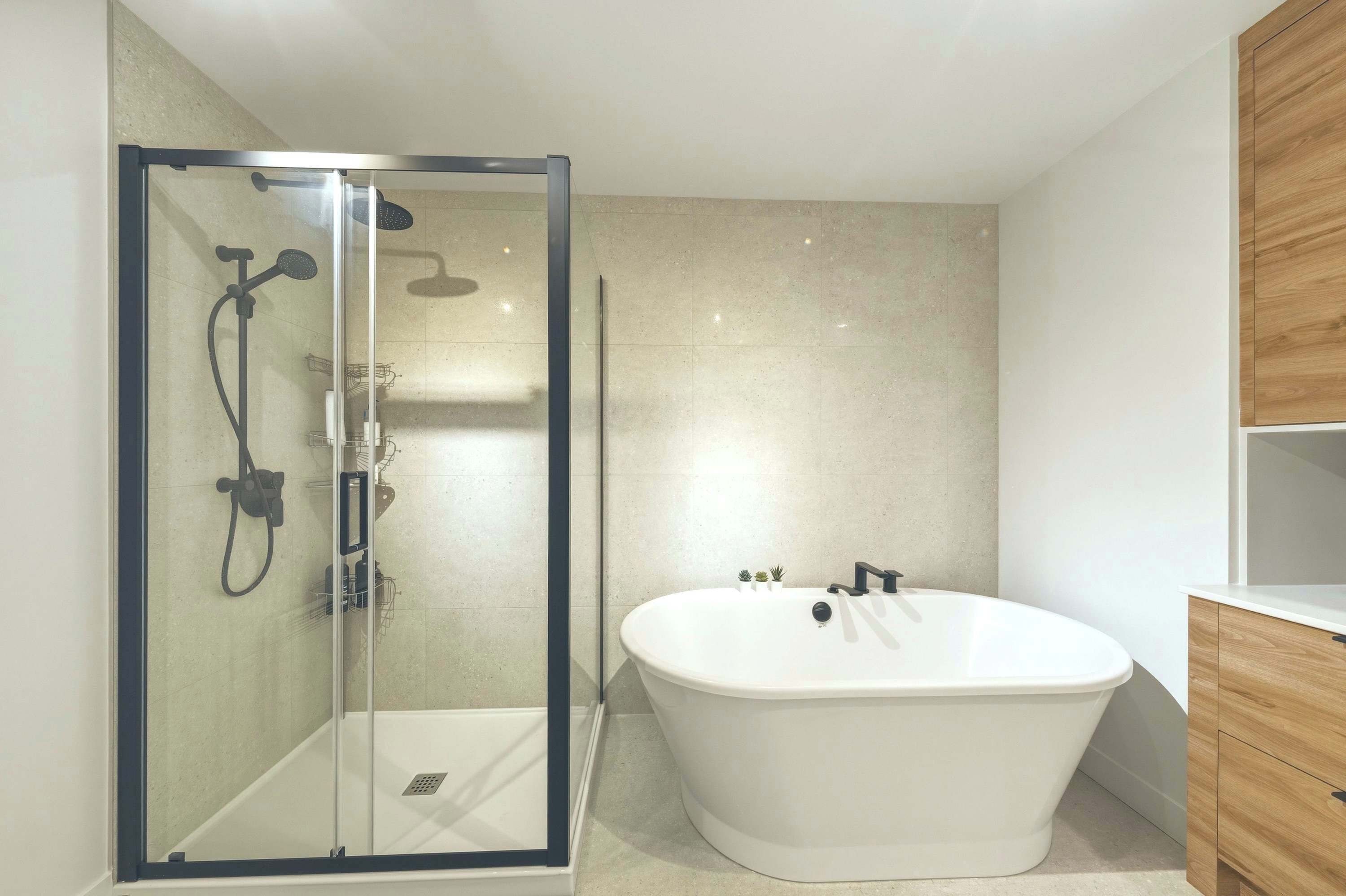 A modern bathroom with a glass-enclosed shower, a freestanding bathtub, and wooden cabinetry.
