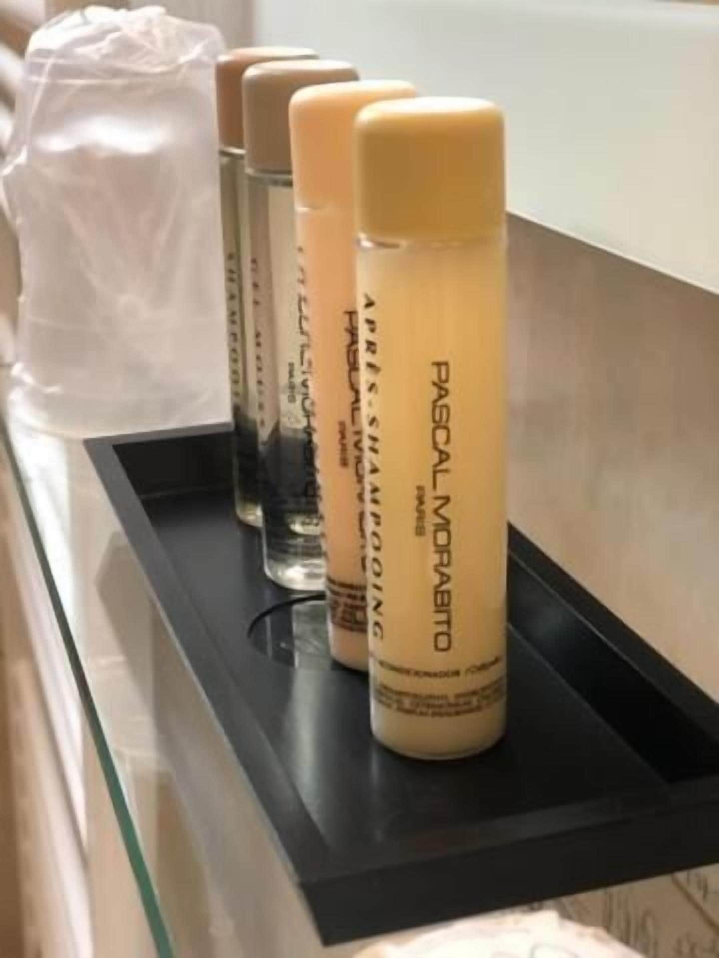 A row of hair care products on a black tray.