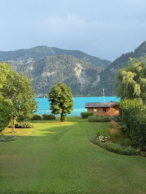 A house with a view of a lake and mountains. - Exclusive villa on Lake Attersee, right on the shore, with a boathouse featuring a seating area and a dock (Unterach am Attersee)