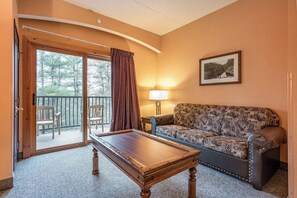 A room with a pool table, a sofa, a chair, a balcony with a view of trees, and a lamp. - Spacious 3-bedroom condo @ Chula Vista Resort in superb Wisconsin Dells (Wisconsin Dells)
