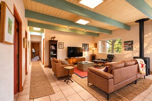 A cozy living room with a fireplace, a television, and a bookshelf. - Vistas de Las Animas - Sweeping Fall Foliage Views (Arroyo Seco)