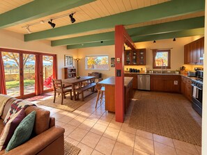 Una cocina amplia con comedor, una pared de acento roja y vistas al exterior.