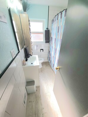 A bathroom with a toilet, sink, and shower area. - Charming 5-bedroom house fits 12 guests in cozy Cheyenne (Cheyenne)