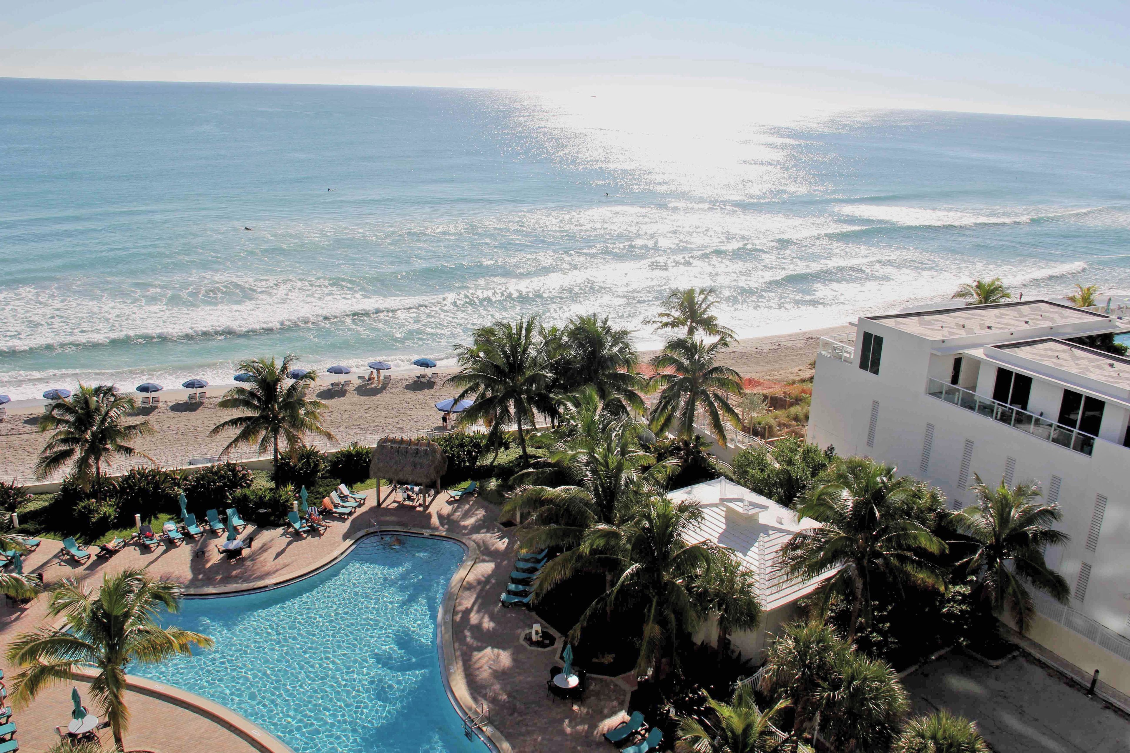 A resort with a pool, beach, and ocean view.