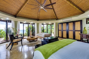 Ein Zimmer mit Bett, einer Sitzecke, einem Tisch und Blick ins Freie.