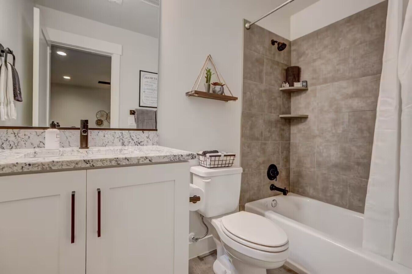 Une salle de bain avec des toilettes blanches, une baignoire et un espace douche.