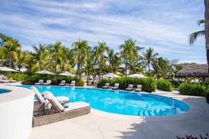 A swimming pool with lounge chairs and umbrellas, surrounded by palm trees. - Elegance - Jungle Meet With Private Pool Heated (Bucerías)