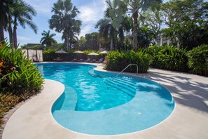 A swimming pool with a curved design, surrounded by lush greenery and palm trees. - Elegance - Jungle Meet With Private Pool Heated (Bucerías)