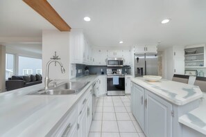 A modern kitchen with white cabinetry, stainless steel appliances, and a large island with a sink. - Waterfront Sodus Gem w/ Dock, Game Loft, Bay View (Sodus Point)