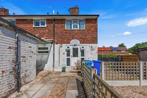 A residential property with a brick facade, a white door, and a small garden area. - Modern 3BR Home Perfect for Groups and families (Little Hulton)