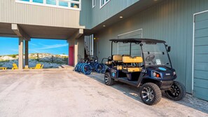 A golf cart parked outside a building with a covered area and a view of a beach. - Matarangi by Avantstay Gulf-front Grayton Beach Retreat Pool + Golf Cart Near Gulf Place (Santa Rosa Beach)