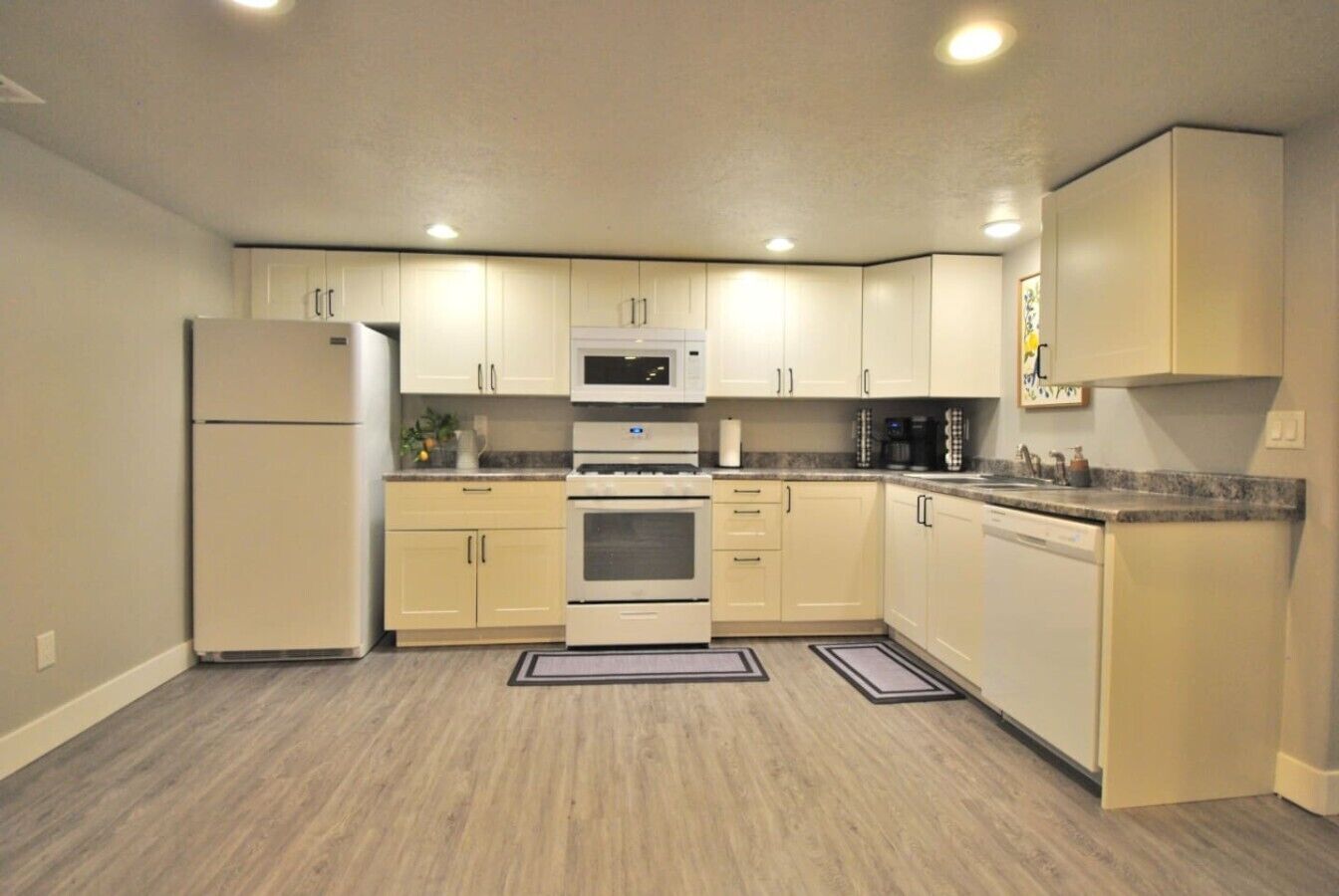 A compact kitchen with a refrigerator, microwave, oven, and dishwasher.