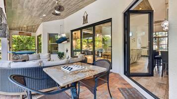 An outdoor living area with a sofa, dining table, and chairs.