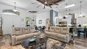 A spacious living room with two beige sofas, a coffee table, and a kitchen area with modern appliances. - A Peaceful Paradise by Avantstay Screened Pool + Outdoor Kitchen + Fire Table 15 Min to 5th Ave (Naples)