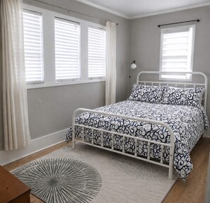A bedroom with a bed, a nightstand, a lamp, and a window with curtains. - Work & Relax / Charming 1BR by GATech & West Midtown & Atlantic Station (Atlanta)