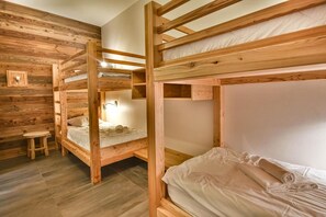 A bunk bed room with wooden walls and a small stool. - Wifi, 2nd floor, view resort, fitness, sauna, balcony, parking, ski locker, 82m², Les Gets (Les Gets)