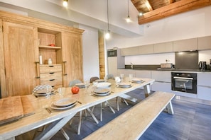 A modern kitchen with a dining area, wooden cabinets, and a built-in oven. - Wifi, 2nd floor, view resort, fitness, sauna, balcony, parking, ski locker, 82m², Les Gets (Les Gets)