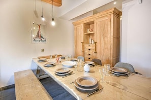 A dining area with a long wooden table set for four, equipped with plates, glasses, and cutlery. - Wifi, 2nd floor, view resort, fitness, sauna, balcony, parking, ski locker, 82m², Les Gets (Les Gets)