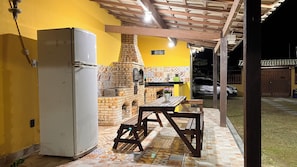 Eine Küche mit Backofen, Kühlschrank und einem Holztisch.