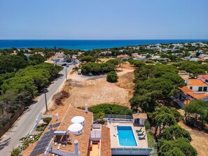 Zona residencial con piscina, paneles solares y vista al mar.