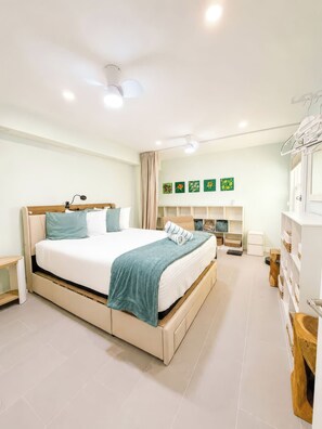 A modern bedroom with a large bed, bedside tables, a wardrobe, and a ceiling fan. - Gulffront Paradise at Vacation Villa (Fort Myers Beach)
