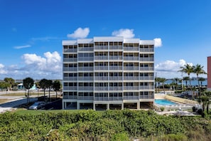 A multi-story hotel with balconies, a swimming pool, and a view of the sea. - Gulffront Paradise at Vacation Villa (Fort Myers Beach)
