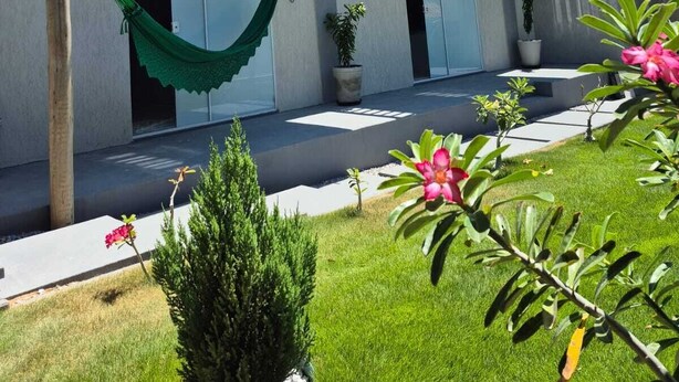 A modern two-story building with balconies, a hammock, and potted plants. - Vrbo Property (Aracati)