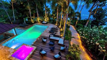Un espace piscine comprenant un jacuzzi, des chaises longues et une terrasse.