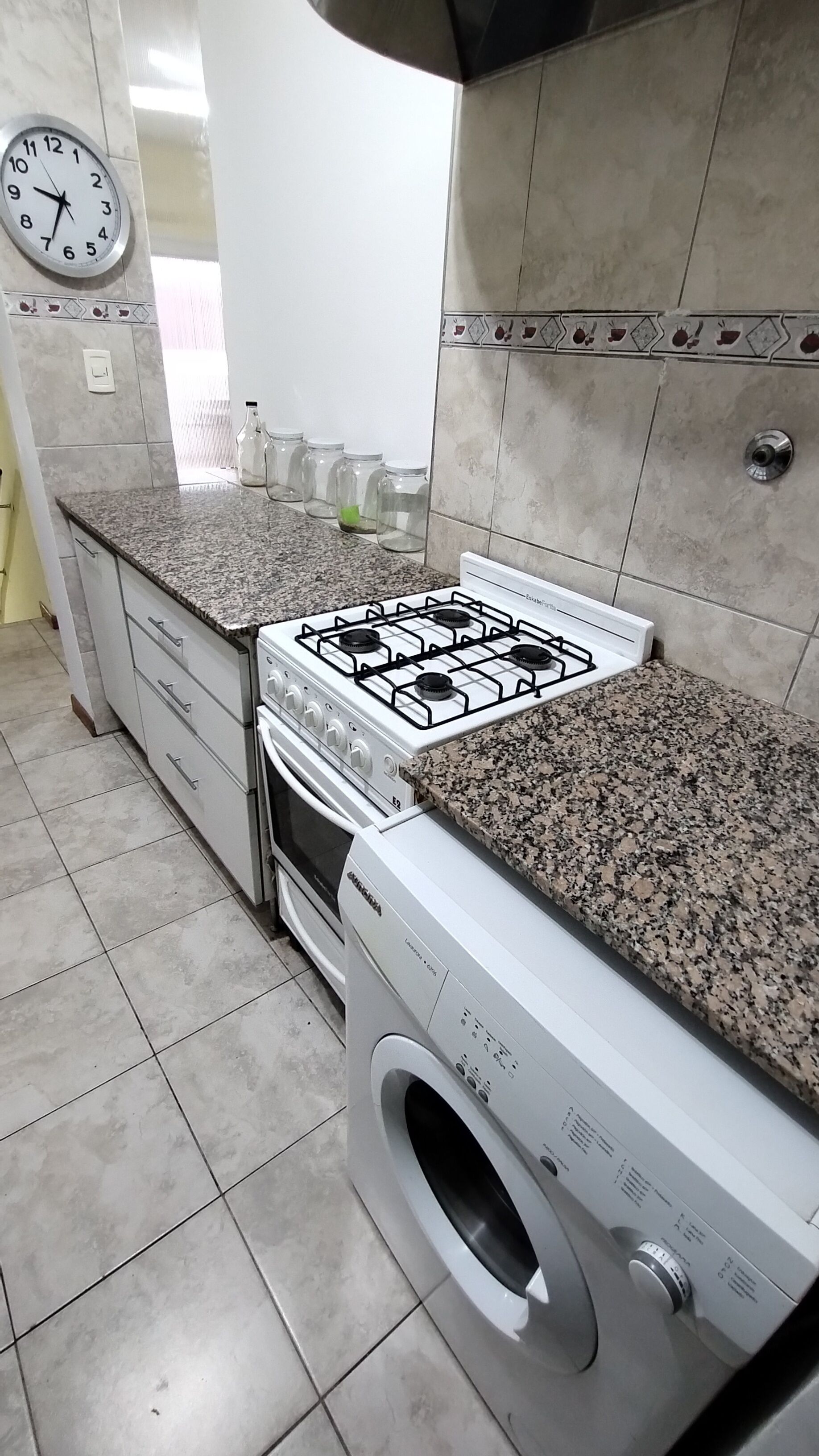 A kitchen with a gas stove, oven, and built-in washing machine.