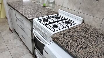 A kitchen with a gas stove, oven, and built-in washing machine.