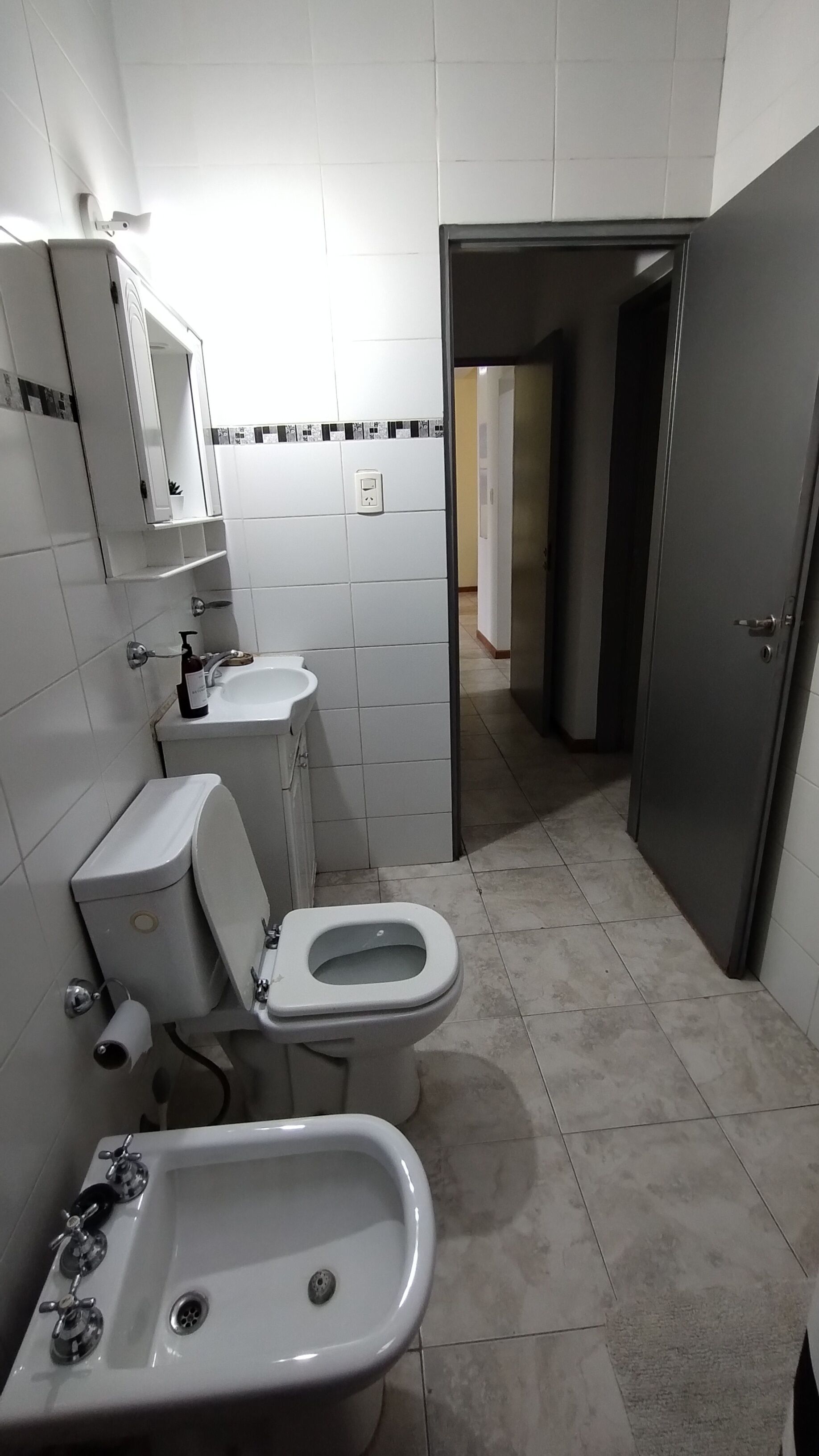 Un baño con inodoro, bidé y lavamanos.