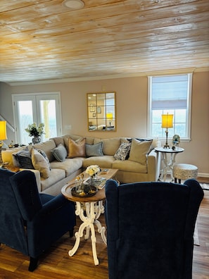 A living room with a sofa, chairs, a coffee table, and a lamp.