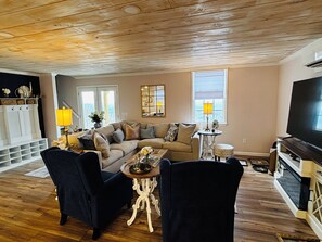 A living room with a sofa, chairs, a coffee table, and a television. - Cozy 2-bedroom cottage in beautiful Mentone, AL family friendly modern amenities (Mentone)